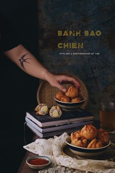 a person reaching for some food on top of a table next to other plates and bowls