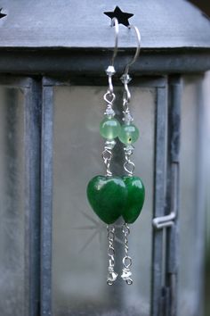 Love that makes you practically glow, a happiness that draws everyone to you, that extra spark that makes some of them green with envy--you know what that is. Either you have it or you don't. Luckily, you always will have it when you wear these darling, charming, delicate earrings. Sterling silver chain links the green jade hearts and soft perinite in a pairing so simple and elegant that you can't help but wish all things could be so delicious.   Earrings measure 3 inches. Green Heart Earrings, Green Heart Sterling Silver Earrings, Green Jade Earrings For Healing, Green Heart-shaped Hypoallergenic Jewelry, Hypoallergenic Green Heart Jewelry, Darling Charming, Diy Earrings Easy, Artsy Jewelry, Fabric Flower Brooch