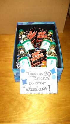 a box filled with lots of different kinds of snacks on top of a wooden table