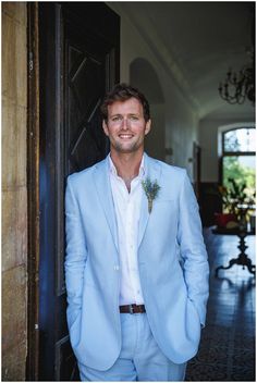 a man in a blue suit standing by a door