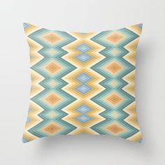 a pillow with an abstract pattern on the front and back, in blue, green, yellow