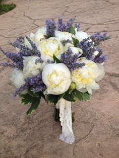 a bouquet of white and purple flowers on the ground