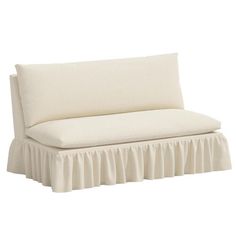 a white couch with a ruffled skirt on it's back and the seat upholstered