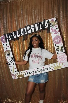 a woman standing in front of a photo booth with a happy birthday sign on it