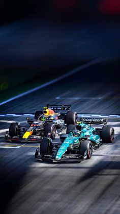 three racing cars driving on a race track at night with motion blurry in the background