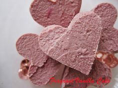 pink heart shaped candies sitting on top of a white plate next to each other