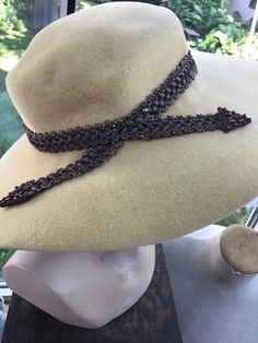 "Vintage 1940s 1950s wide brim hat. The color is a light Butterscotch color. The hat feels like a soft fur felt. Has a band around the crown made of Brown cording with Copper color beads. The band is shaped like an arrow. The label is: Rane'l Original. The design on the tag is adorable. CONDITION: Has 2 darker discolorations on the underside of the brim (SEE PIX). MEASURES: Inside circumference-23\" Left to right-14\" Front to back-14\" **WE APOLOGIZE~BUT WE CAN NO LONGER SHIP TO ITALY OR SPAIN. Butterscotch Color, 1950s Hat, Hat Wide Brim, Vintage Clothing Boutique, Color Beads, Wide Brimmed Hats, Brim Hat, Copper Color, Wide Brimmed