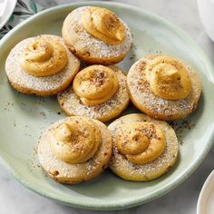 a green plate topped with cookies covered in powdered sugar on top of a table