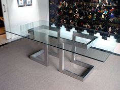 a glass table with metal legs in a room