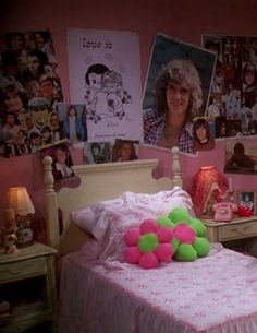 a bedroom with pink walls and pictures on the wall