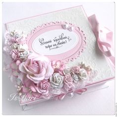 a close up of a card with flowers and ribbon on the front, in pink