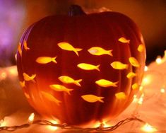 a pumpkin with glowing fish carved on it