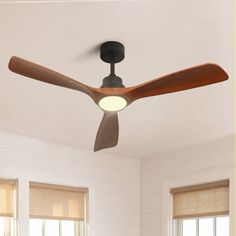 a ceiling fan that is mounted to the ceiling in a room with white walls and windows