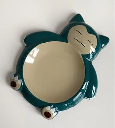 a green and white plate with a cat design on the front, sitting on top of a table