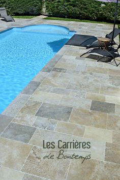 an empty swimming pool surrounded by lawn chairs and umbrellas with the words les carriers de bonteries written on it