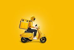 a man riding on the back of a yellow scooter with a suitcase strapped to it