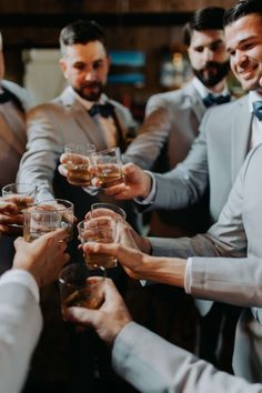 a group of men in suits toasting with glasses