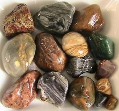 many different colored rocks in a white bowl