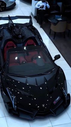 a black sports car with red seats in a showroom