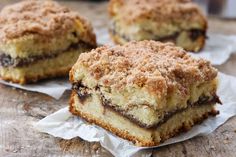 three pieces of cake sitting on top of a wooden table