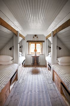 there are three beds in the room with white walls and wood trim on the ceiling