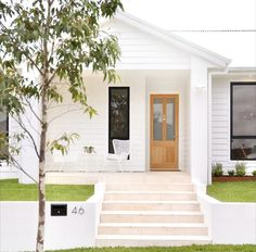 a white house with steps leading to the front door