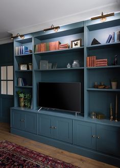 a living room filled with blue bookshelves and a flat screen tv