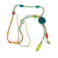 Brave ALMA necklace CARNIVAL ... an eclectic blend of exceptional beads from diverse parts of the world. Each bead is uniquely fashioned from either natural or man-made materials including gemstones (Turquoise, Howlite), recycled glass, bone, various other glass, and more. Every MOJO is one of a kind ... crafted and designed by gifted ladies on the island of Carriacou. FIDEL Productions is a small cottage industry based on the island of Carriacou, with a strong focus on quality craftsmanship using natural materials that stand the test of time. You can find us on Paradise Beach, Carriacou, or at the Port Louis Marina, Grenada.  FIDEL productions Paradise Beach, Carriacou, Grenada, West Indies Phone 1473 435-8866 shopFIDEL.com FIDELgrenada@gmail.com Bohemian Long Necklace With Wooden Beads, Green Wooden Beads For Festival, Green Wooden Beads For Festivals, Bohemian Long Green Necklace With Colorful Beads, Bohemian Green Long Necklace With Colorful Beads, Hippie Style Green Beaded Necklaces With Round Beads, Green Hippie Beaded Necklaces, Bohemian Long Green Necklace, Bohemian Green Beads, Gems, And Cabochons