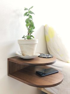 a phone is sitting on a shelf next to a potted plant and cellphone