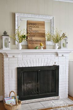 a white brick fireplace in a living room with flowers on the mantel and a sign above it