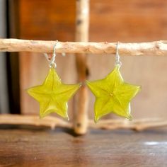 two yellow stars are hanging from silver earwires