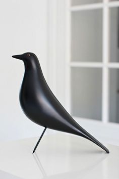 a black bird sitting on top of a white table