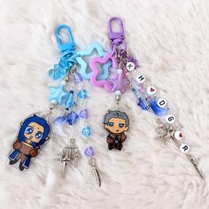 several keychains with cartoon characters on them sitting on a white furnishing