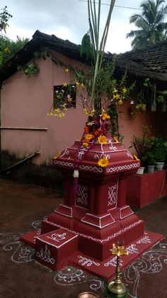 a red fire hydrant with yellow flowers on it in front of a pink house