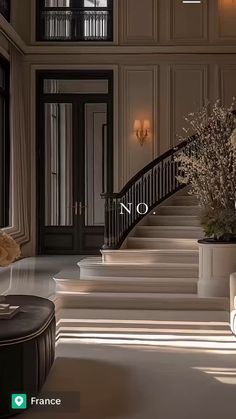 a staircase leading to the second floor in a luxurious home with chandeliers on either side