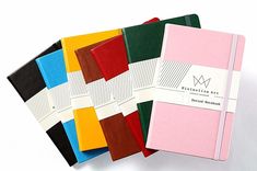 five different colored notebooks sitting next to each other