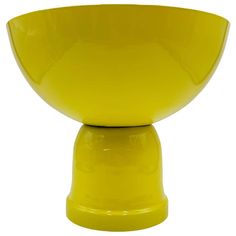 a yellow bowl sitting on top of a white table