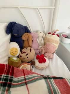 several stuffed animals are sitting on the bed