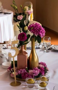 a table topped with vases filled with flowers and wine glasses next to each other