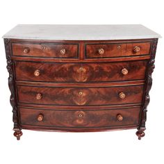 an antique chest of drawers with marble top