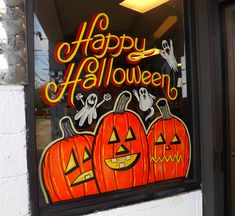 a store front window decorated for halloween with pumpkins