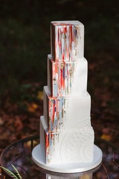 a three tiered white cake with red and blue icing