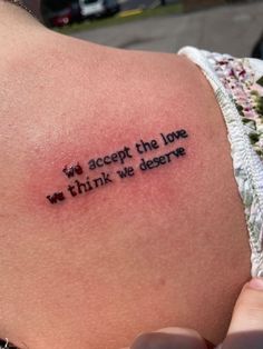 a woman with a tattoo saying accept the love we think we deserves