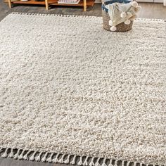 a white rug with fringes on the floor in a living room