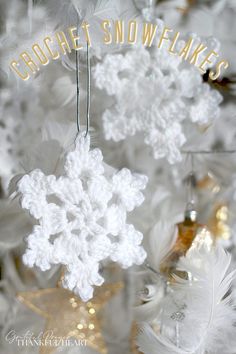 white crocheted snowflake ornaments hanging from a christmas tree with feathers in the foreground