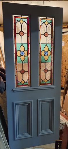 the front door is painted blue and has two stained glass panels on each side of it