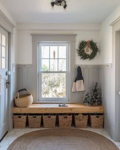 the entryway is clean and ready for guests to come home with their belongings in baskets on the bench