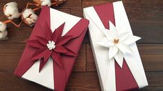 two wrapped gift boxes sitting on top of a wooden table