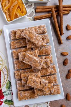 there are many pieces of food on the plate next to some nuts and cinnamon sticks