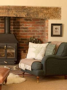 a living room filled with furniture and a fire place in front of a brick wall